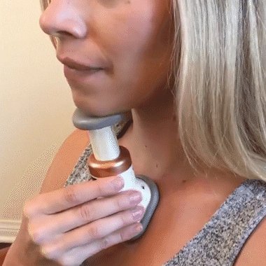 Young woman using the neck firming device in upward strokes to show correct technique